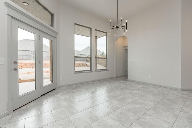 9120 SW 34th St, Oklahoma City, OK 73179 - unfurnished dining area with healthy amount of natural light, a chandelier, arched walkways, and light tile patterned floors