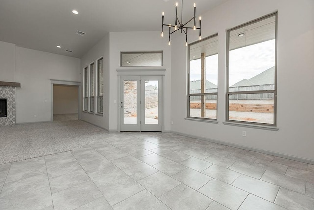 9120 SW 34th St, Oklahoma City, OK 73179 - unfurnished living room featuring a tile fireplace, a chandelier, recessed lighting, light tile patterned flooring, and a high ceiling