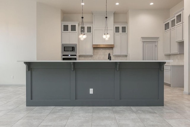 9120 SW 34th St, Oklahoma City, OK 73179 - kitchen featuring appliances with stainless steel finishes, decorative backsplash, a large island, recessed lighting, and light countertops
