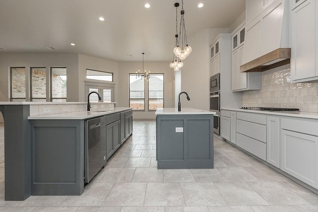 9120 SW 34th St, Oklahoma City, OK 73179 - kitchen featuring a kitchen island with sink, appliances with stainless steel finishes, a chandelier, tasteful backsplash, and light countertops