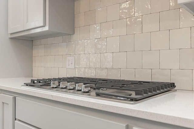 9120 SW 34th St, Oklahoma City, OK 73179 - kitchen view of stainless steel gas stovetop, light countertops, and decorative backsplash