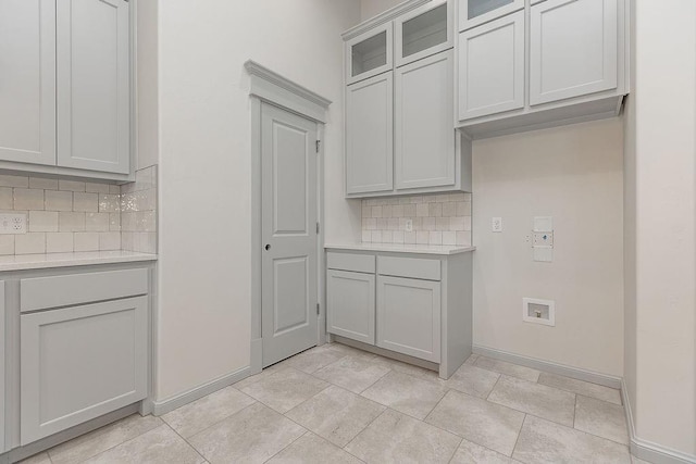 9120 SW 34th St, Oklahoma City, OK 73179 - kitchen with tasteful backsplash, light countertops, baseboards, and glass insert cabinets