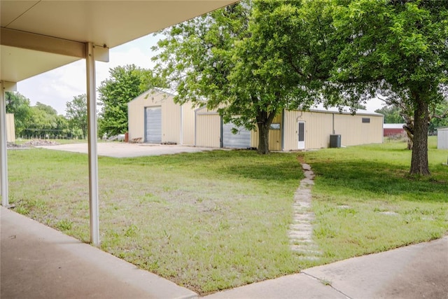 5624 N Mueller Ave, Bethany, OK 73008 - view of grassy yard with an outdoor structure, central AC unit, and a garage
