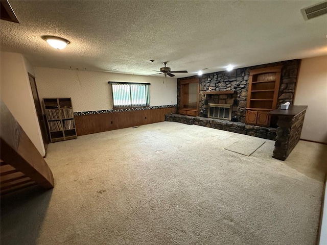 5624 N Mueller Ave, Bethany, OK 73008 - unfurnished living room with a fireplace, a textured ceiling, carpet, a ceiling fan, and a wainscoted wall