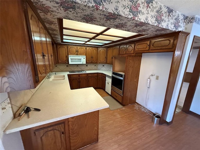 5624 N Mueller Ave, Bethany, OK 73008 - kitchen featuring white microwave, stainless steel oven, wallpapered walls, light countertops, and light wood-style floors