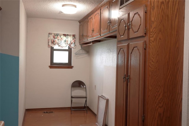5624 N Mueller Ave, Bethany, OK 73008 - laundry room featuring light wood-style flooring and a textured ceiling