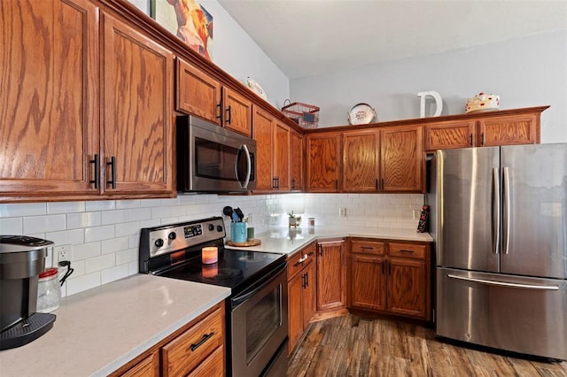 4125 Queens Dr, Moore, OK 73160 - kitchen featuring stainless steel appliances, light countertops, brown cabinets, dark wood-type flooring, and decorative backsplash