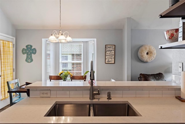 4125 Queens Dr, Moore, OK 73160 - kitchen with a sink, a chandelier, light countertops, and pendant lighting