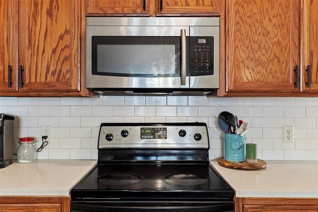 4125 Queens Dr, Moore, OK 73160 - kitchen featuring stainless steel appliances, brown cabinets, and tasteful backsplash