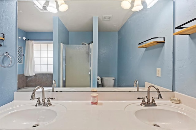 4125 Queens Dr, Moore, OK 73160 - bathroom with a stall shower, a textured wall, toilet, and double vanity