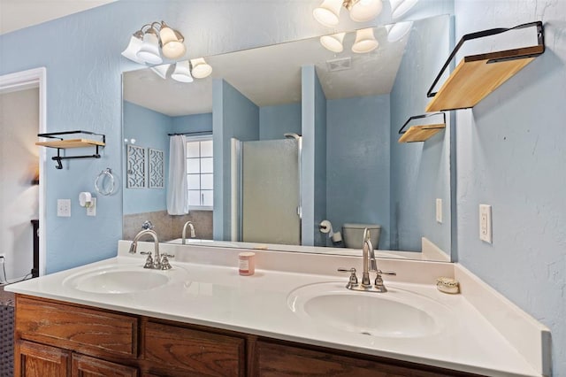 4125 Queens Dr, Moore, OK 73160 - bathroom featuring toilet, double vanity, and a shower with shower door