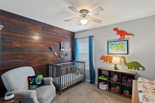 4125 Queens Dr, Moore, OK 73160 - bedroom with a crib, wood walls, carpet, ceiling fan, and baseboards
