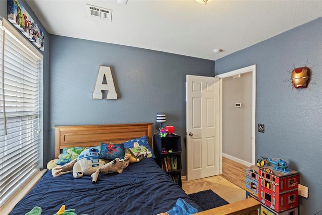 4125 Queens Dr, Moore, OK 73160 - bedroom featuring multiple windows, carpet floors, baseboards, and a textured wall