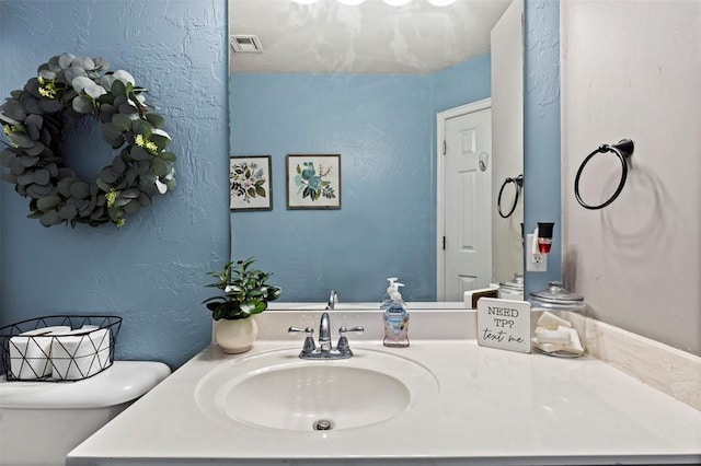 4125 Queens Dr, Moore, OK 73160 - half bath featuring toilet, vanity, and a textured wall