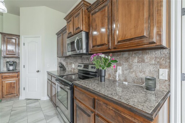 2504 NW 180th St, Edmond, OK 73012 - kitchen featuring appliances with stainless steel finishes, backsplash, and dark stone countertops