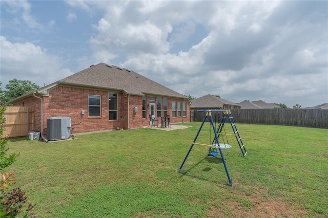 2504 NW 180th St, Edmond, OK 73012 - rear view of house with cooling unit, brick siding, a playground, a patio, and a shingled roof