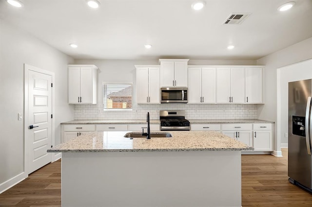 11904 SW 30th St, Yukon, OK 73099 - kitchen with appliances with stainless steel finishes, a sink, wood finished floors, backsplash, and recessed lighting