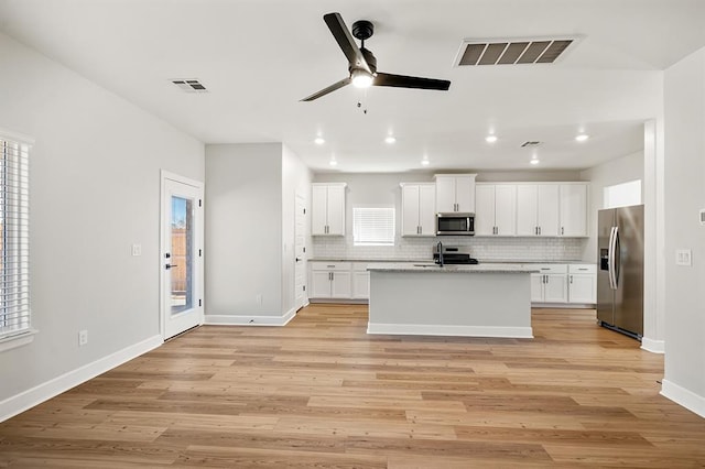 11904 SW 30th St, Yukon, OK 73099 - kitchen with appliances with stainless steel finishes, ceiling fan, decorative backsplash, baseboards, and light wood-type flooring