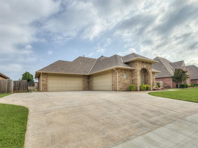 1017 SW 107th St, Oklahoma City, OK 73170 - view of front of house featuring a garage, driveway, brick siding, and roof with shingles