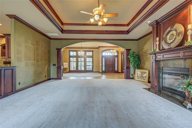 12509 St Lukes Ln, Oklahoma City, OK 73142 - unfurnished living room featuring arched walkways, light carpet, a tray ceiling, a premium fireplace, and crown molding