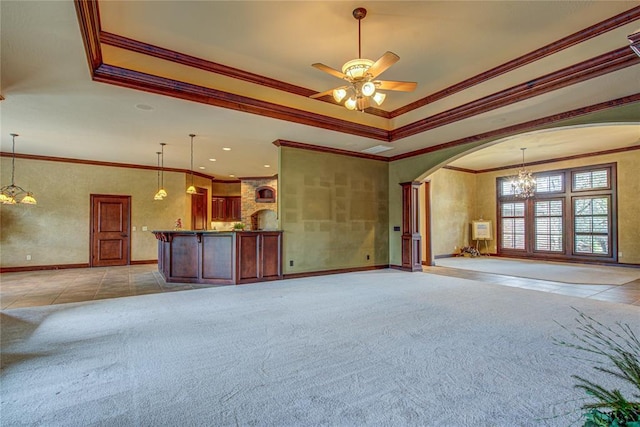 12509 St Lukes Ln, Oklahoma City, OK 73142 - unfurnished living room featuring a chandelier, ornamental molding, a tray ceiling, arched walkways, and baseboards