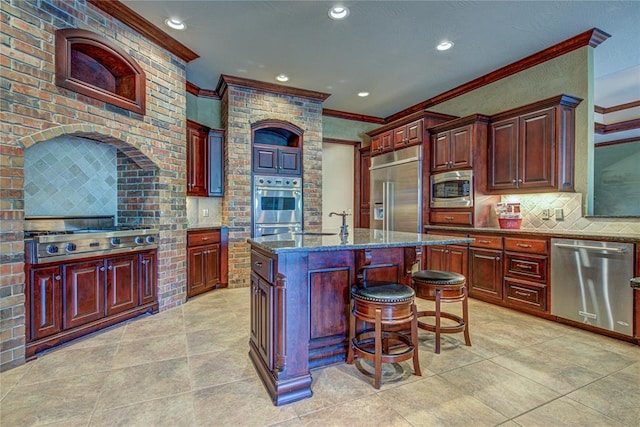 12509 St Lukes Ln, Oklahoma City, OK 73142 - kitchen with appliances with stainless steel finishes, crown molding, tasteful backsplash, a sink, and dark stone countertops