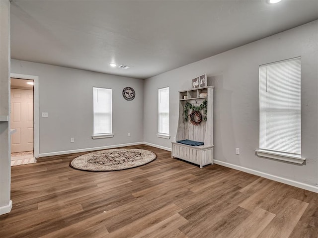 foyer featuring baseboards, wood finished floors, and recessed lighting