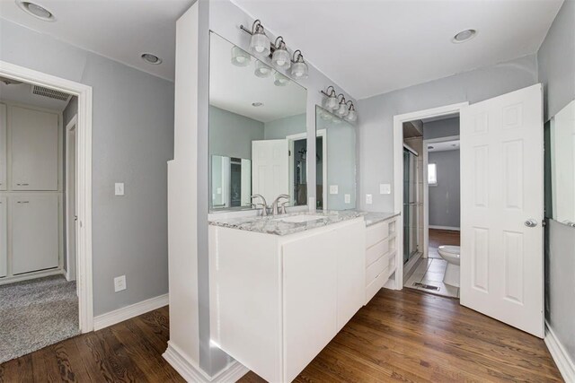 2109 Brighton Ave, Oklahoma City, OK 73120 - full bath with wood finished floors, baseboards, vanity, toilet, and a stall shower