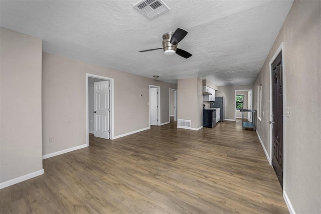 3134 NW Ferris Ave, Lawton, OK 73505 - unfurnished living room featuring dark wood-style flooring, a ceiling fan, baseboards, and a textured ceiling
