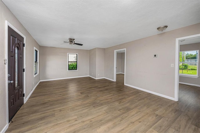 3134 NW Ferris Ave, Lawton, OK 73505 - empty room with baseboards, wood finished floors, a ceiling fan, and a textured ceiling