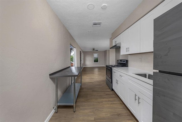 3134 NW Ferris Ave, Lawton, OK 73505 - kitchen featuring stainless steel electric range, freestanding refrigerator, baseboards, white cabinets, and a textured ceiling