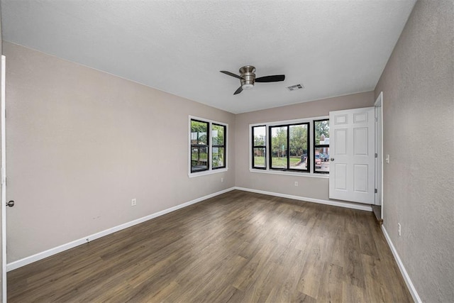 3134 NW Ferris Ave, Lawton, OK 73505 - unfurnished room featuring ceiling fan, dark wood-style floors, baseboards, and a textured wall