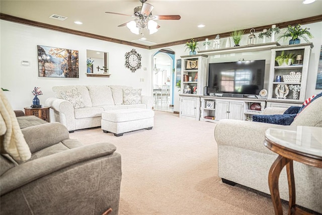 8100 N Burns Rd, Edmond, OK 73025 - carpeted living room with crown molding, a ceiling fan, arched walkways, and recessed lighting