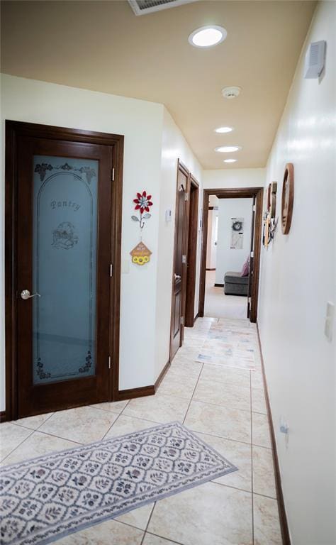 8100 N Burns Rd, Edmond, OK 73025 - hall featuring light tile patterned floors, baseboards, and recessed lighting