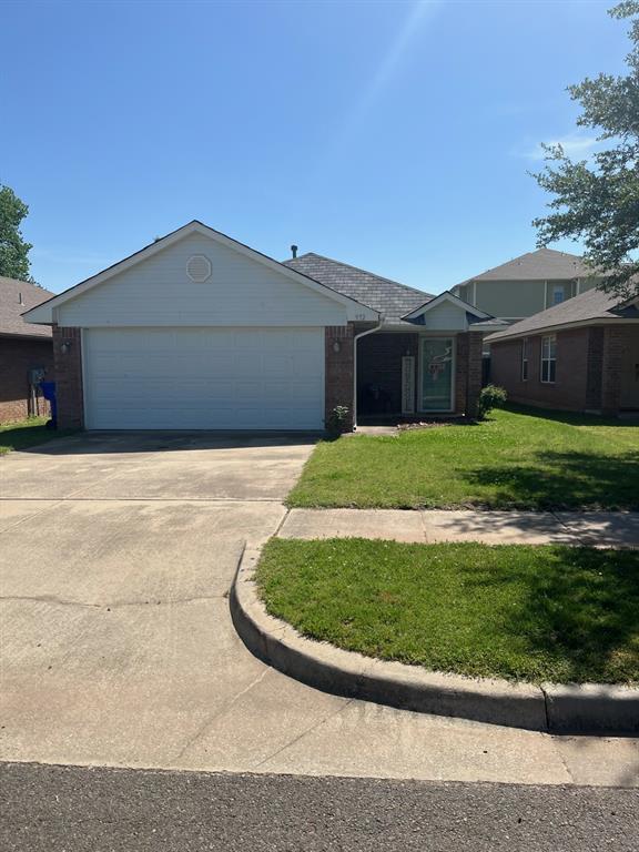 932 Beaumont Sq, Norman, OK 73071 - ranch-style house with brick siding, driveway, a front yard, and an attached garage