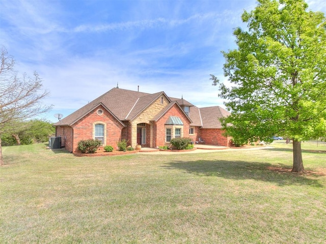 5877 W Washington Ave, Piedmont, OK 73078 - view of front of house featuring brick siding, a front lawn, roof with shingles, and central AC unit
