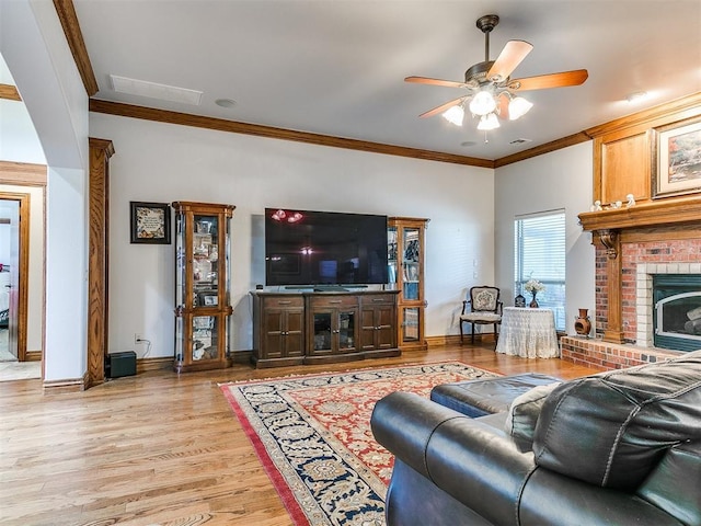 5877 W Washington Ave, Piedmont, OK 73078 - living area with crown molding, ceiling fan, light wood finished floors, a brick fireplace, and baseboards