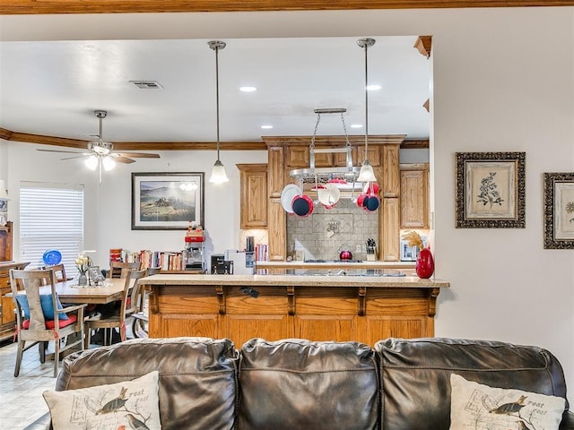 5877 W Washington Ave, Piedmont, OK 73078 - kitchen featuring crown molding, a ceiling fan, pendant lighting, tasteful backsplash, and brown cabinets
