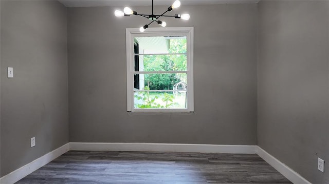 617 Holman Pl, Midwest City, OK 73110 - unfurnished room with a chandelier, baseboards, and wood finished floors