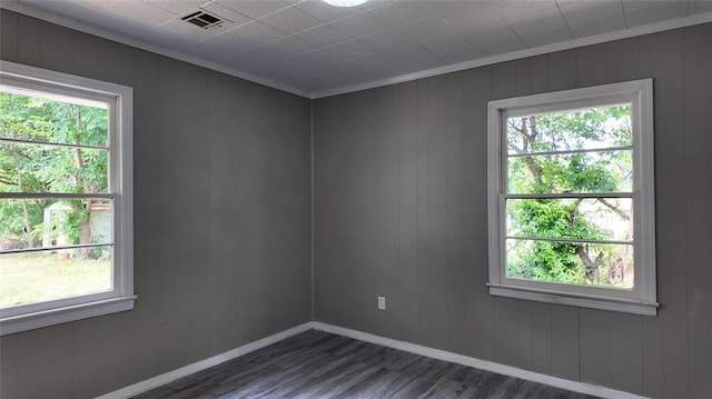 617 Holman Pl, Midwest City, OK 73110 - spare room featuring dark wood-style floors, crown molding, healthy amount of natural light, and baseboards
