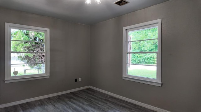 617 Holman Pl, Midwest City, OK 73110 - spare room featuring plenty of natural light, dark wood finished floors, and baseboards