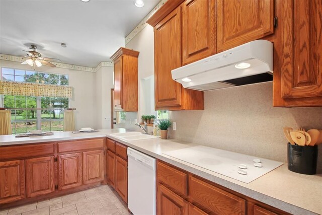 1227 Stout Dr NW, Piedmont, OK 73078 - kitchen with white appliances, under cabinet range hood, light countertops, brown cabinetry, and ceiling fan
