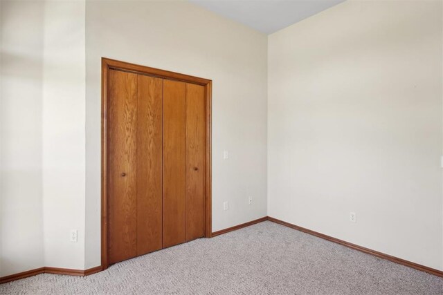 1227 Stout Dr NW, Piedmont, OK 73078 - unfurnished bedroom featuring light carpet, baseboards, and a closet