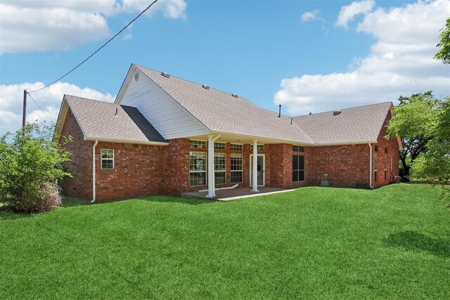 1227 Stout Dr NW, Piedmont, OK 73078 - back of house featuring brick siding, a yard, a patio area, and a shingled roof