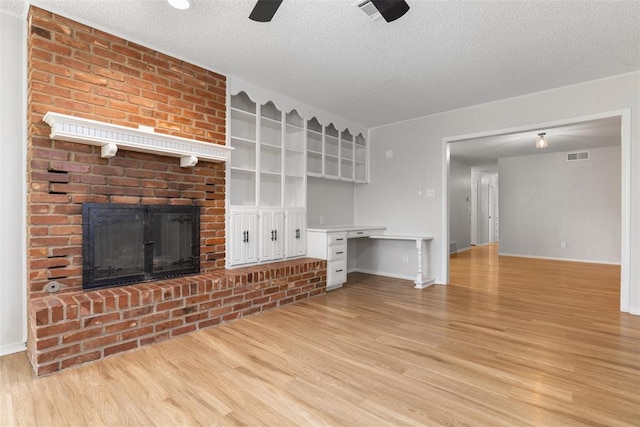 6 Utah Ave, Yukon, OK 73099 - unfurnished living room featuring light wood finished floors, a fireplace, a textured ceiling, and baseboards