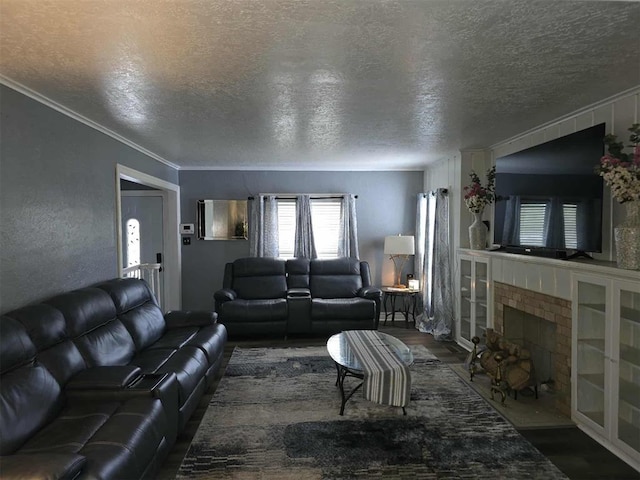 915 NW Euclid Ave, Lawton, OK 73507 - living room featuring a textured ceiling, wood finished floors, a fireplace, and crown molding