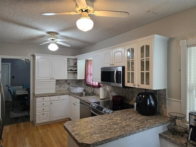 915 NW Euclid Ave, Lawton, OK 73507 - kitchen with appliances with stainless steel finishes, a sink, a ceiling fan, open shelves, and light wood-style flooring