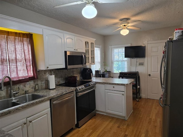 915 NW Euclid Ave, Lawton, OK 73507 - kitchen featuring stainless steel appliances, ceiling fan, a sink, a peninsula, and a textured ceiling