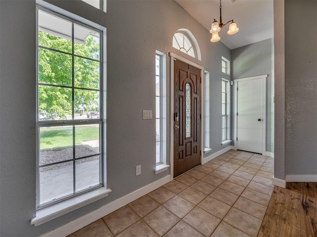 1900 New Haven Ct, Moore, OK 73160 - entrance foyer with a textured wall, healthy amount of natural light, light tile patterned flooring, lofted ceiling, and a chandelier