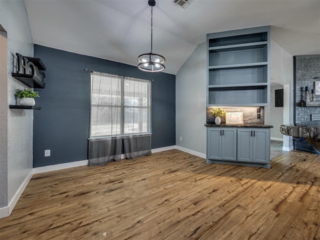 1900 New Haven Ct, Moore, OK 73160 - bar area featuring a chandelier, wood finished floors, baseboards, vaulted ceiling, and decorative light fixtures